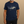 Man wearing a navy blue t-shirt with a shark diagram on a beige background