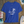Blue t-shirt with a palm tree design on a wooden surface