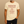 Man wearing a t-shirt with a sloth graphic and text on a beige background