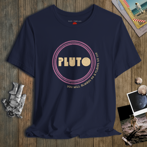 Navy blue t-shirt with 'PLUTO' graphic on a wooden surface with space-themed items.