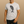 Man wearing a light gray t-shirt with a whale graphic and text on a beige background
