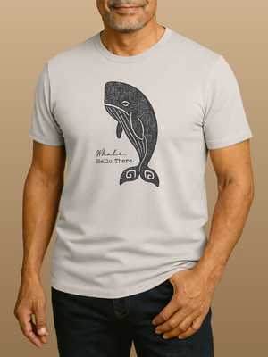 Man wearing a light gray t-shirt with a whale graphic and text on a beige background