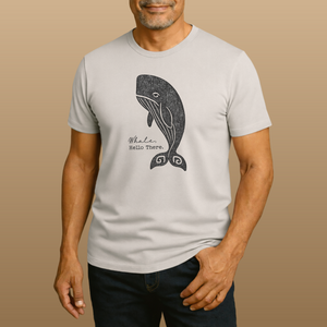 Man wearing a light gray t-shirt with a whale graphic and text on a beige background